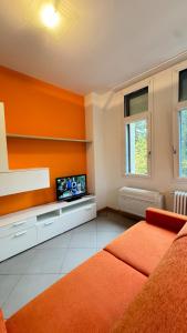 a living room with a couch and a tv at Dimora delle Terme in Porretta Terme