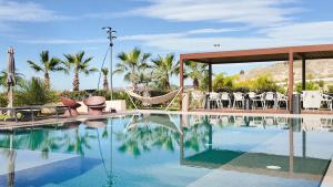 a swimming pool with chairs and a hammock in a resort at Terreforti Boutique Spa & Glamping in Agrigento +203 photos