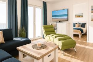 ein Wohnzimmer mit Sofa, Sesseln und Fernseher in der Unterkunft Weitblick in Schillig