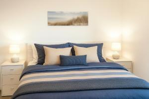 ein Schlafzimmer mit einem blauen Bett und zwei Lampen in der Unterkunft Weitblick in Schillig