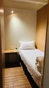 a small bedroom with a bed and a desk at FarGo Hotels By Lowfare Hotels in Bangalore