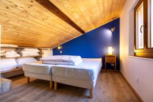 a bedroom with two beds and a wooden ceiling at L’Écrin des Neiges - Proche Station de Ski in Formiguères
