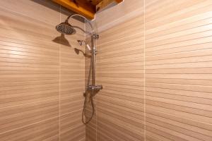 a shower with a shower head on a wooden wall at L’Écrin des Neiges - Proche Station de Ski in Formiguères +6 photos