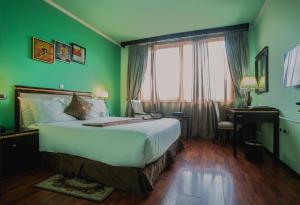 ein Schlafzimmer mit einem großen Bett und grünen Wänden in der Unterkunft Wassamar Hotel in Addis Abeba
