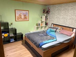 a bedroom with a bed and a brick wall at Capybara Guest House in Spittal an der Drau