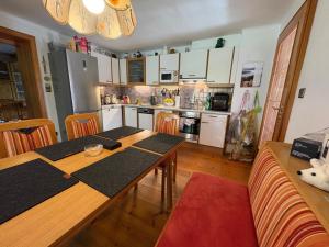 a kitchen with a wooden table and a dining room at Capybara Guest House in Spittal an der Drau