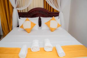 a bed with white sheets and orange pillows at Zeylon Villa Talalla in Matara