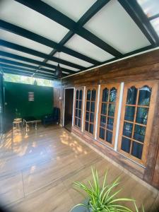 a large screened in porch with wood floors and windows at Casita Greens in Kondotti