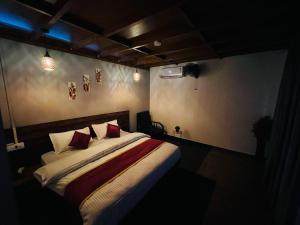 a bedroom with a bed with red pillows at Casita Greens in Kondotti +62 photos