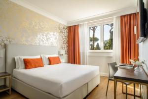 a bedroom with a bed and a desk and a window at Hotel Shangri-La Roma by OMNIA hotels in Rome +58 photos