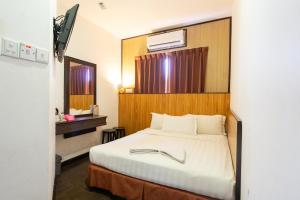 a bedroom with a large bed with a wooden headboard at Sipadan Inn 1 in Semporna