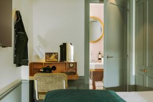 a bedroom with a bed and a table and a mirror at Hôtel Casimir in Paris