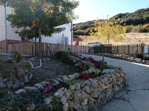 a garden with rocks and flowers next to a fence at Complejo Turístico Fuenmayor in Torres