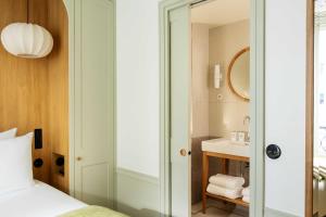 a bathroom with a bed and a sink at Hôtel Casimir in Paris +43 photos
