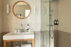 a bathroom with a sink and a shower with a mirror at Hôtel Casimir in Paris