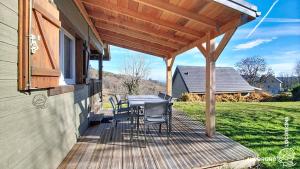 a wooden deck with a table and chairs on a house at Chalet de la Gougère 3 in Chambon-sur-Lac