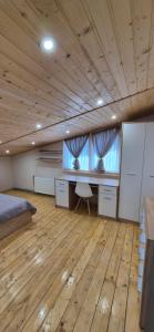 a bedroom with a bed and a desk and a window at B apartment Рахів in Rakhiv +3 photos
