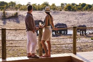 a man and a woman standing on a deck looking at elephants at Maasai Wild Adventure in Gatunga