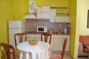 a kitchen with a table and a kitchen with a microwave at Hotel Perla in Gorna Oryakhovitsa