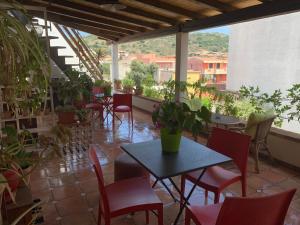 a patio with a table and chairs and plants at Arega Rooms in Villasimius