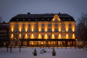 a large building with lights on it in the snow at Piteå Stadshotell in Piteå