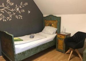 a small bedroom with a bed and a chair at Pension Deinhardt in Hirschaid