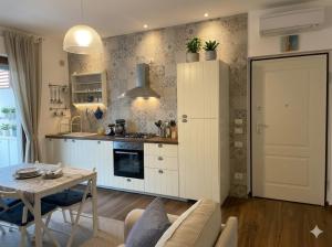 a living room with a table and a kitchen at PIOPPETO OVEST - Premium Villas in Giulianova