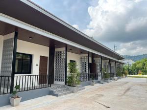 a building with a balcony with potted plants on it at Wanwichai Room in Ban Lam Ru (1) +6 photos