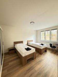 two beds in a room with wooden floors at Mid-Town Spacious Apartment in Banská Bystrica +7 photos