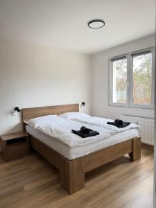 a bedroom with a bed with white sheets and a window at Mid-Town Spacious Apartment in Banská Bystrica
