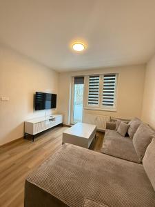 a living room with a couch and a flat screen tv at Mid-Town Spacious Apartment in Banská Bystrica