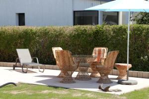 a group of chairs and a table with an umbrella at Ferienbungalow Strandluft in Loissin