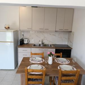 a kitchen with a wooden table with plates and chairs at Holiday Home Klimataria in Áyios Pétros