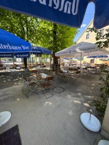 a patio with tables and chairs and umbrellas at Gasthaus - Hotel Neue Post in Meitingen