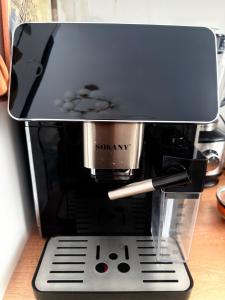 a coffee maker sitting on top of a table at Luxe Hotel in Kazarman