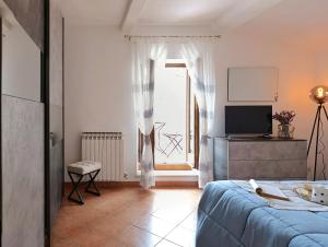 a bedroom with a bed and a tv and a window at Il cantuccio di Federico in Radicofani