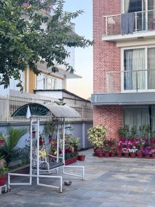 a bench with an umbrella in front of a building at Triluna Apartments in Pātan +10 photos