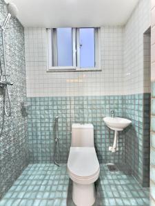 a bathroom with a toilet and a sink at Triluna Apartments in Pātan