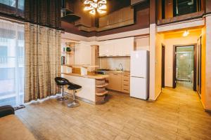 a kitchen with a refrigerator and a stool in it at C&Y Zev Apartments in Mamaia +31 photos