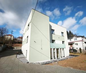 a white building on the side of a street at Vila Olivín - Private rooms with bathroom in Banská Bystrica