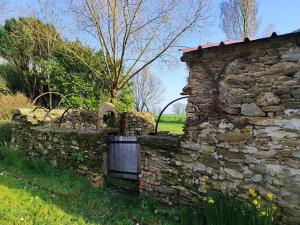 an old stone wall with a gate in a field at L'Orée du Puy in Les Herbiers +28 photos