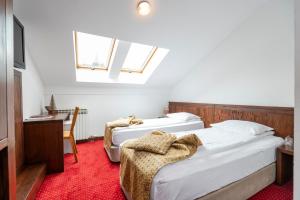 two beds in a room with a red carpet at Garni Konak Hotel By Blanket Collection in Sarajevo +35 photos