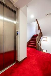 a hallway with a red carpet and stairs at Garni Konak Hotel By Blanket Collection in Sarajevo