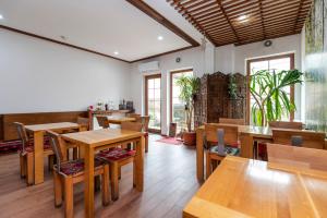 a restaurant with wooden tables and chairs and windows at Garni Konak Hotel By Blanket Collection in Sarajevo