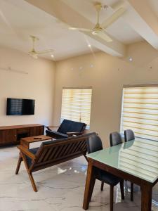 a living room with a table and a piano at Zara Homes in Alleppey