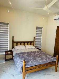 a bedroom with a bed with a wooden frame at Zara Homes in Alleppey