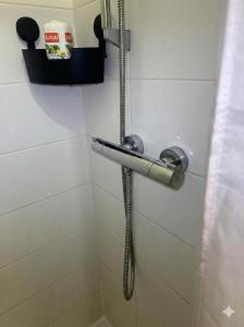 a shower with a hose in a bathroom at Paris Défense T2 Design in Suresnes