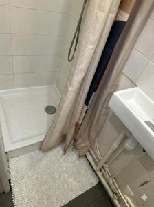 a shower curtain in a bathroom with a sink at Paris Défense T2 Design in Suresnes