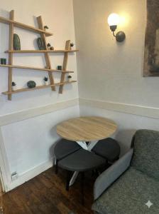 a room with a table and a chair and a couch at Paris Défense T2 Design in Suresnes