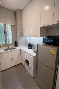 a kitchen with a washing machine and a sink at Oxley Thanksgiving Residence in Singapore